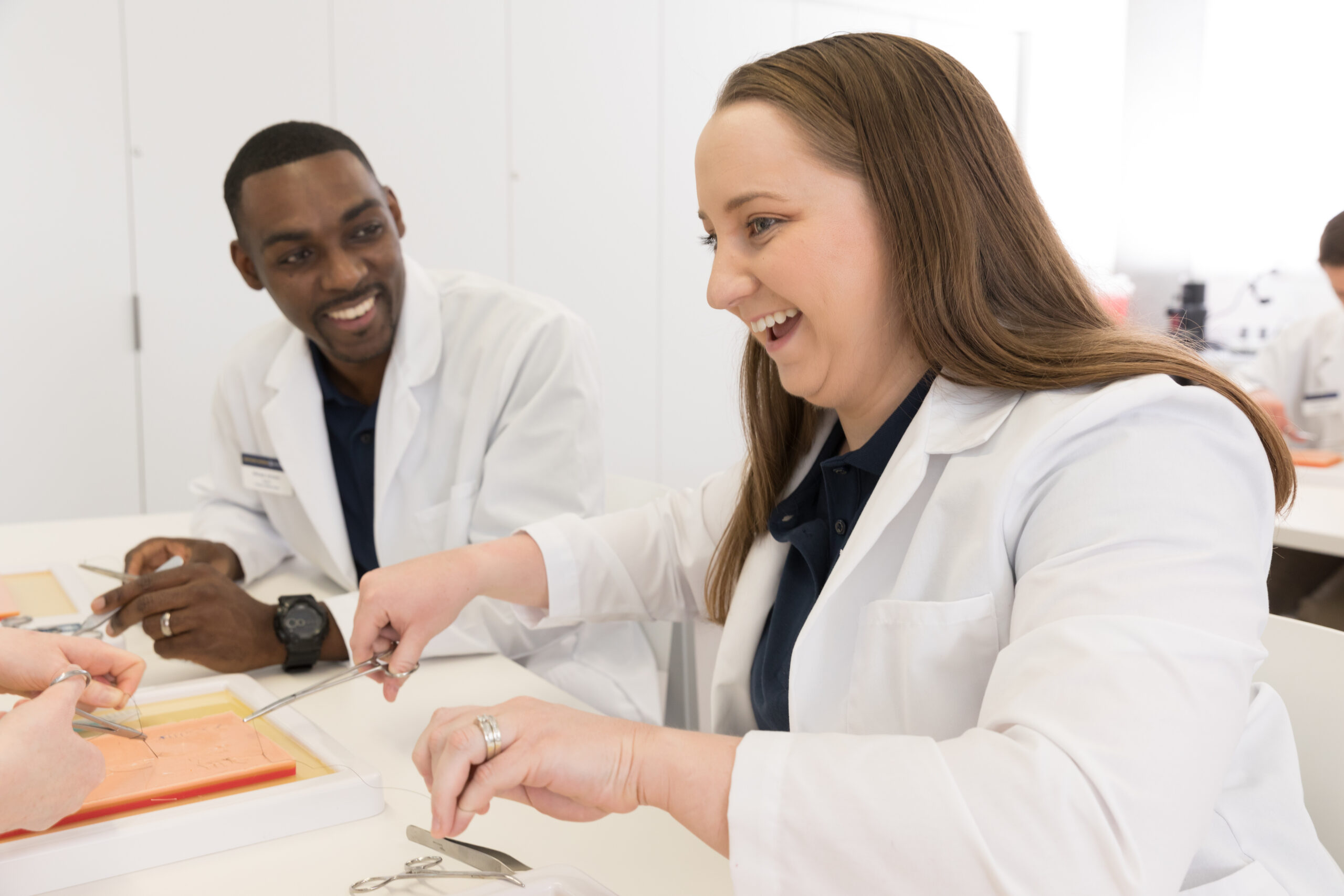 NAU Physician Assistant Studies students have fun while they practice giving stitches in class.