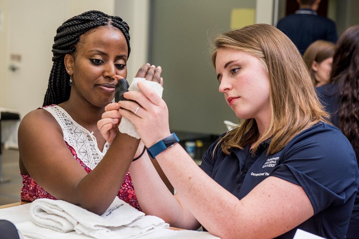An NAU occupational therapist student works with a patient.